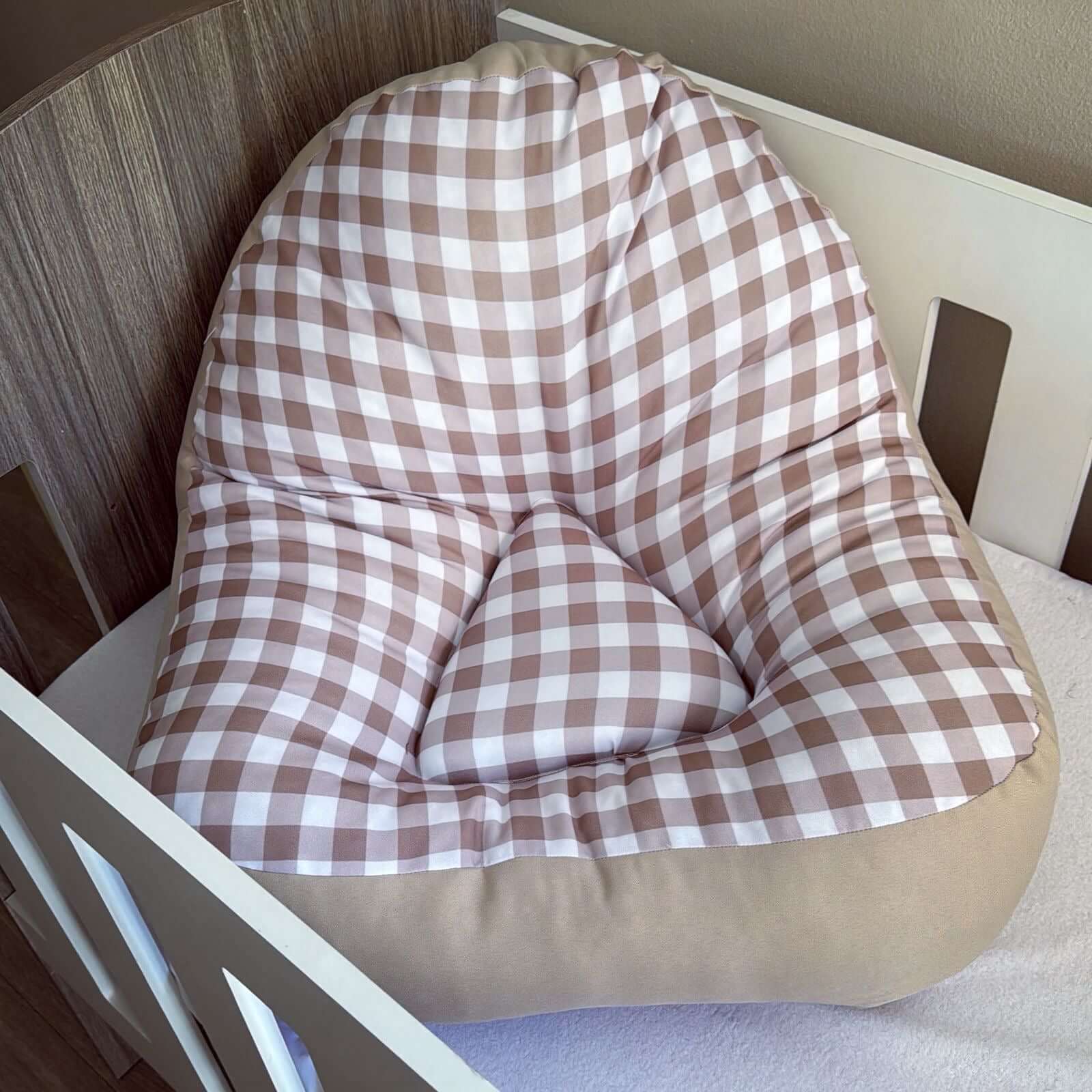 Checkered lounger cushion on a chair with a neutral background