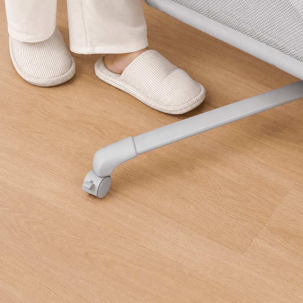 White slippers on a wooden floor with a chair leg in the foreground