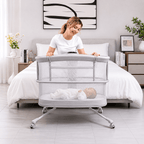 Woman with a baby in a portable dream starlight crib in a bedroom setting