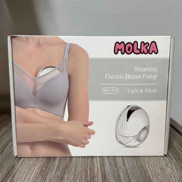 Box of MOLKA wearable electric breast pump on a wooden floor.