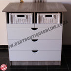 White dresser with three drawers and two wicker baskets on a tiled floor.