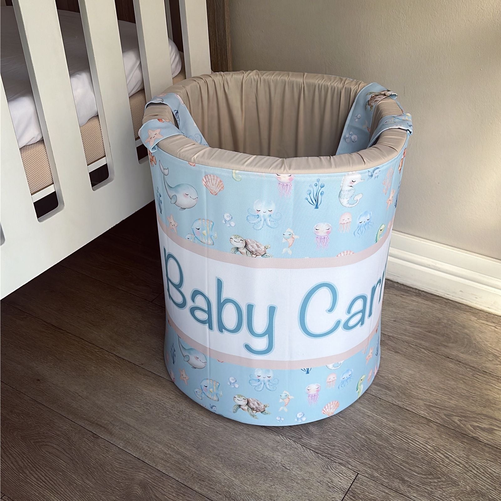 Baby care bin with cartoon designs and 'Baby Care' text in a nursery setting.