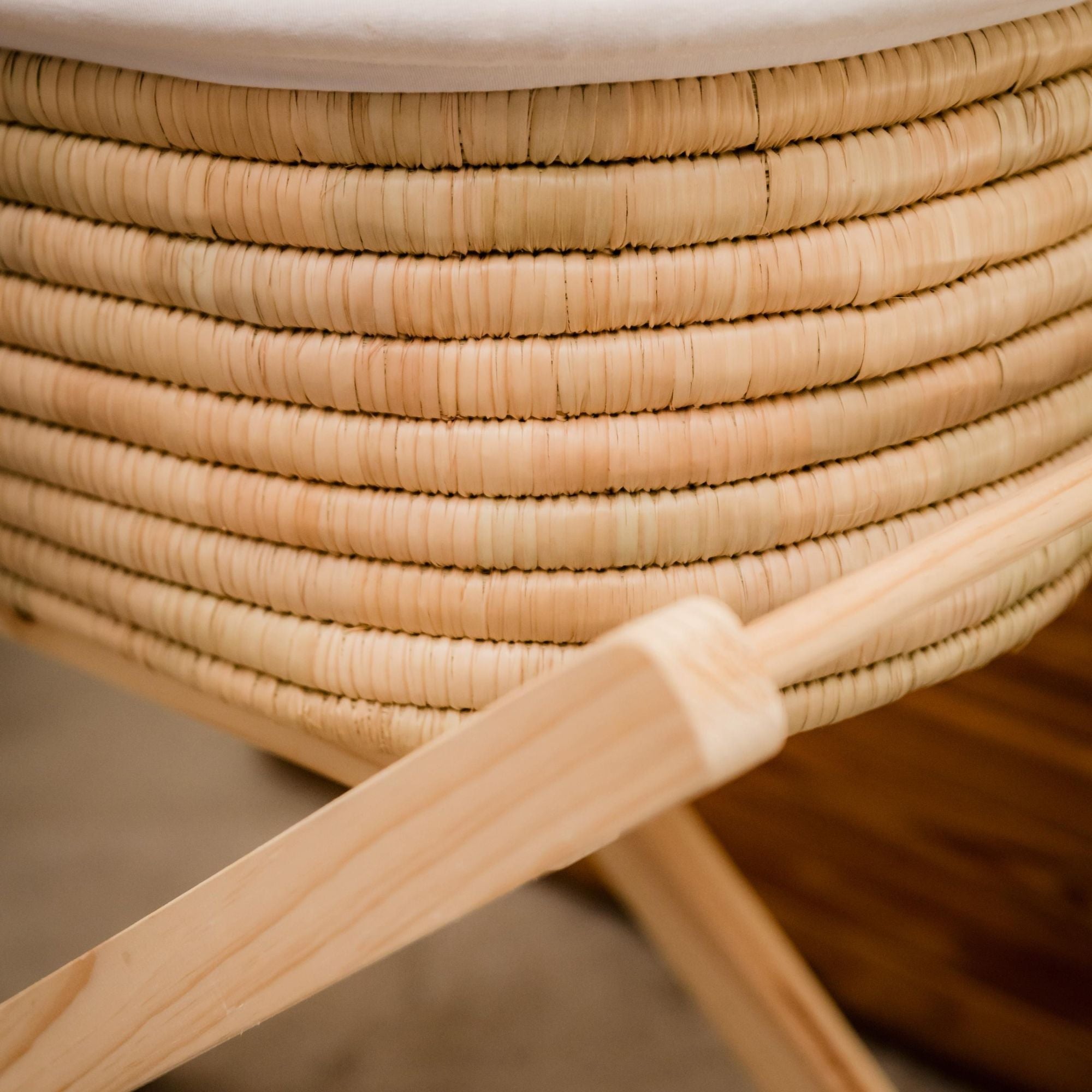 Close-up of a woven basket with a wooden handle on a blurred background