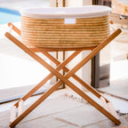 Wicker laundry basket on a wooden stand with a blurred background