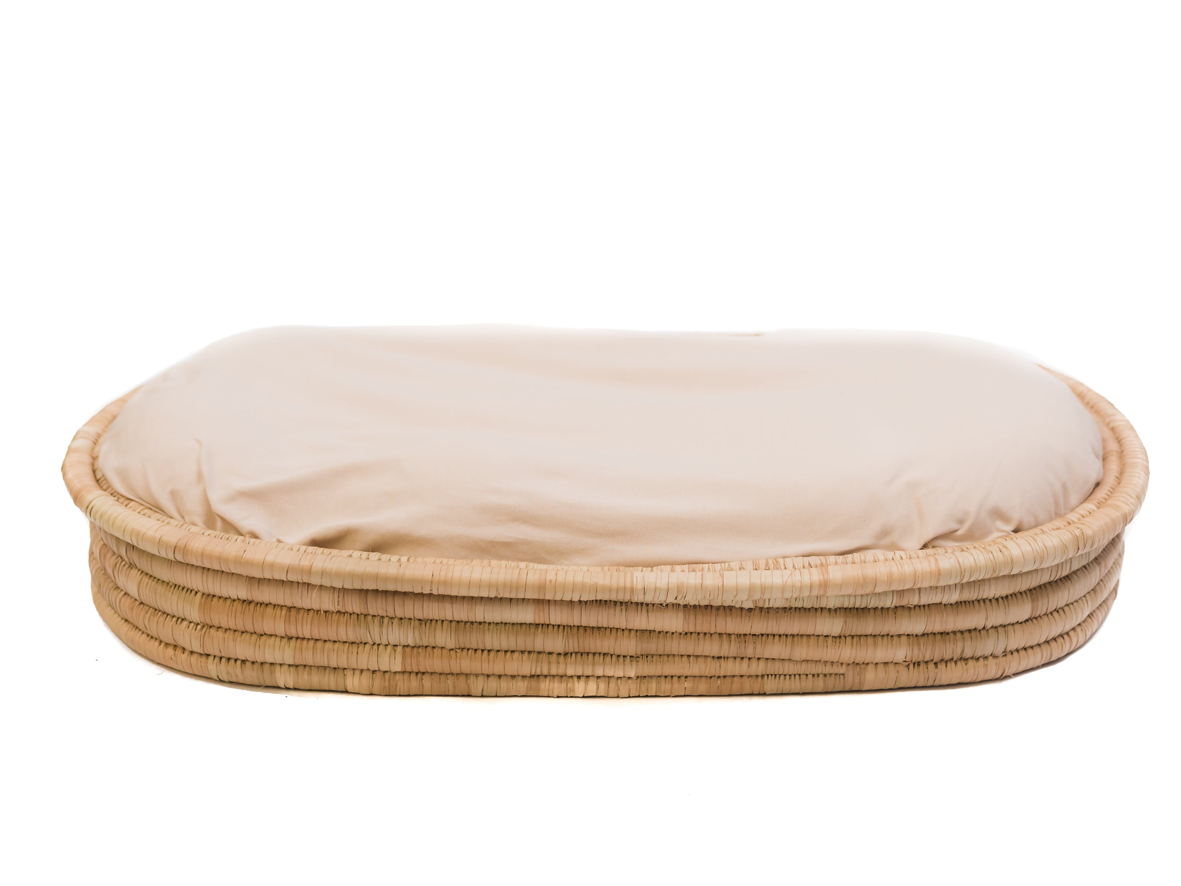 A beige woven basket with a soft mattress on top.
